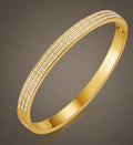 Gold bracelet with diamond accents on a gray background